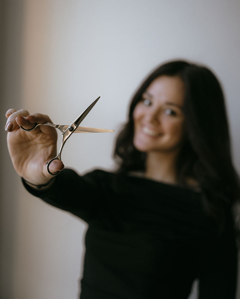 Brodava salon employee holding styling scissors